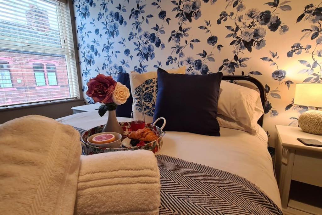 a bedroom with a bed with a basket of flowers on it at Potter's Retreat by Spires Accommodation an adorably quirky place to stay in Stoke on Trent in Longport