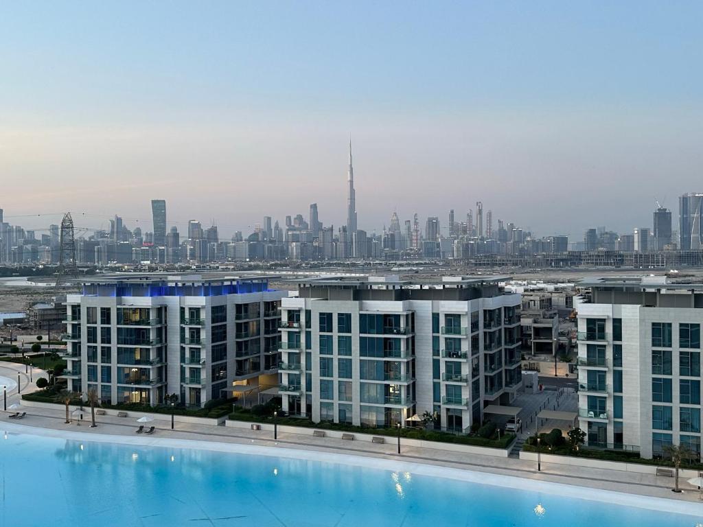 met uitzicht op de skyline van de stad en een groot zwembad bij Oraya - Skyline Serenity at 1BR in District One in Dubai