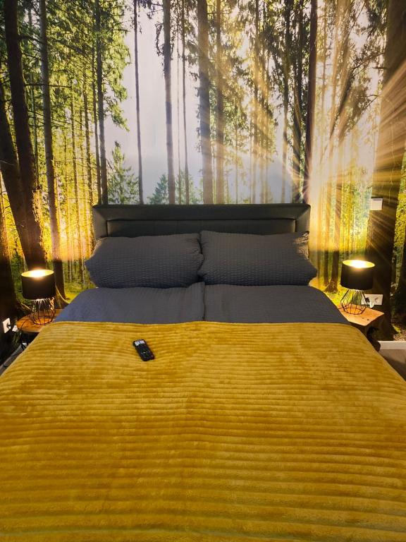 a bedroom with a large bed with a forest backdrop at Wood II Appartement in Bad Salzuflen