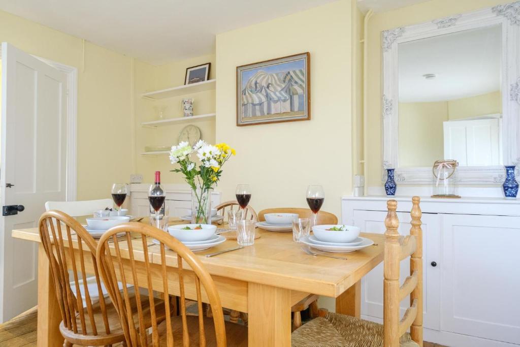 a dining room table with chairs and wine glasses at 41 Eastward Ho in Leiston