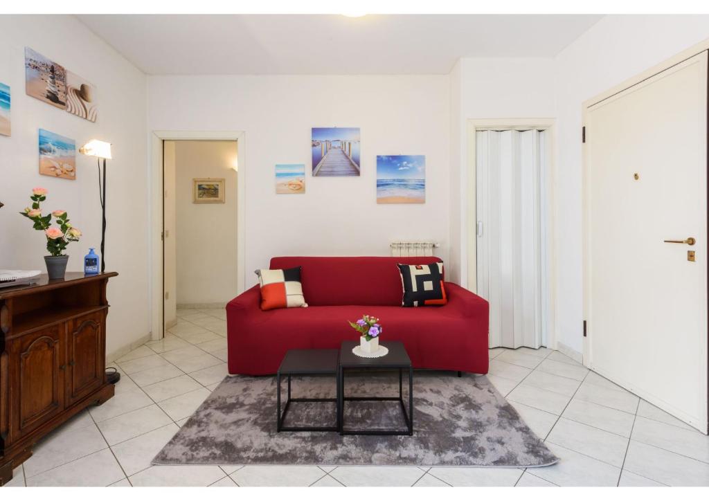 um sofá vermelho numa sala de estar com uma mesa em Sea Air House em Lido di Camaiore