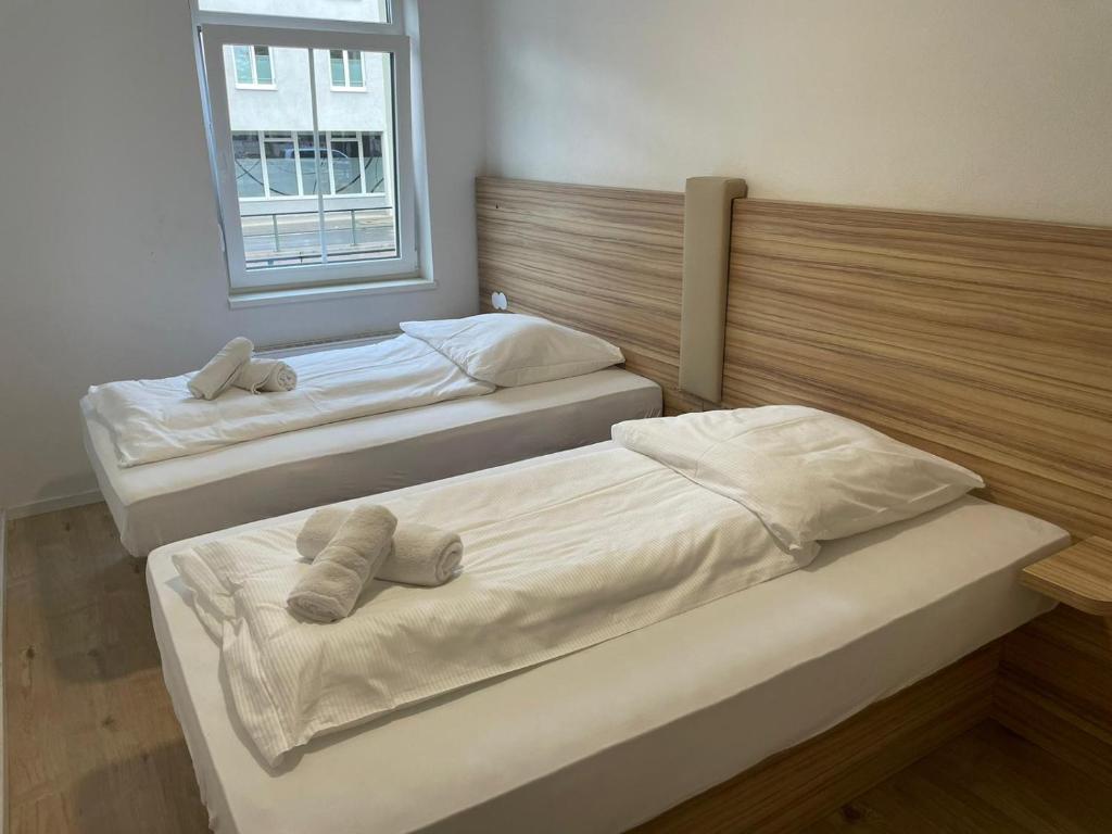 two beds sitting in a room with a window at Timeless: Große Moderne 4 Zimmer Wohnung in Ludwigsburg