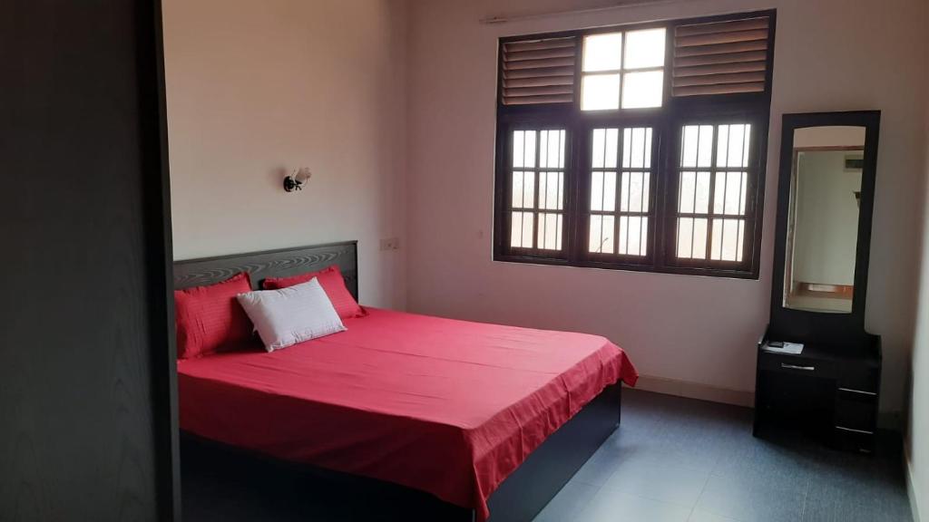 een slaapkamer met een bed met een rode deken en een spiegel bij Party Allowed luxury 4 roomed Furnished house in Jaela in Ja-Ela