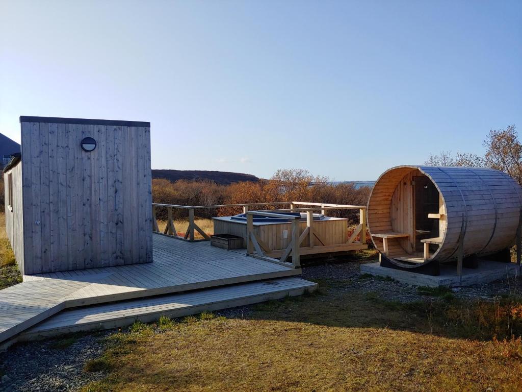 um deque de madeira com uma sauna e uma casa de hobbit em Hotel Hafnarfjall em Borgarnes