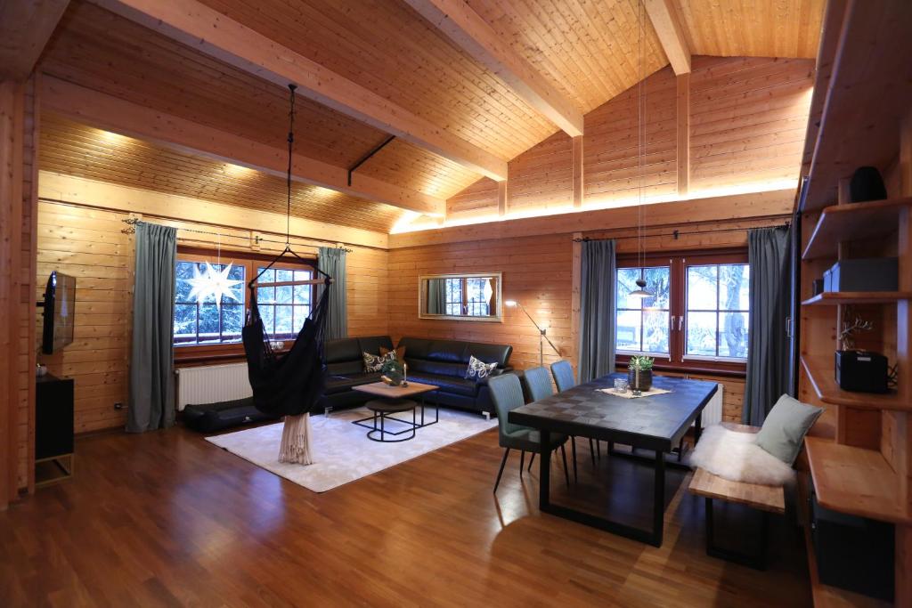 a living room with wooden walls and a wooden ceiling at Bergfreude Chalet in Braunlage