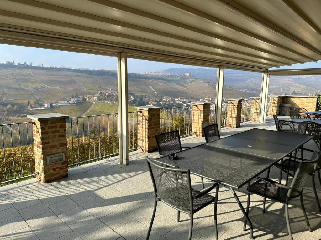 una mesa y sillas en un balcón con vistas en Cascina Boschetti, en Barolo