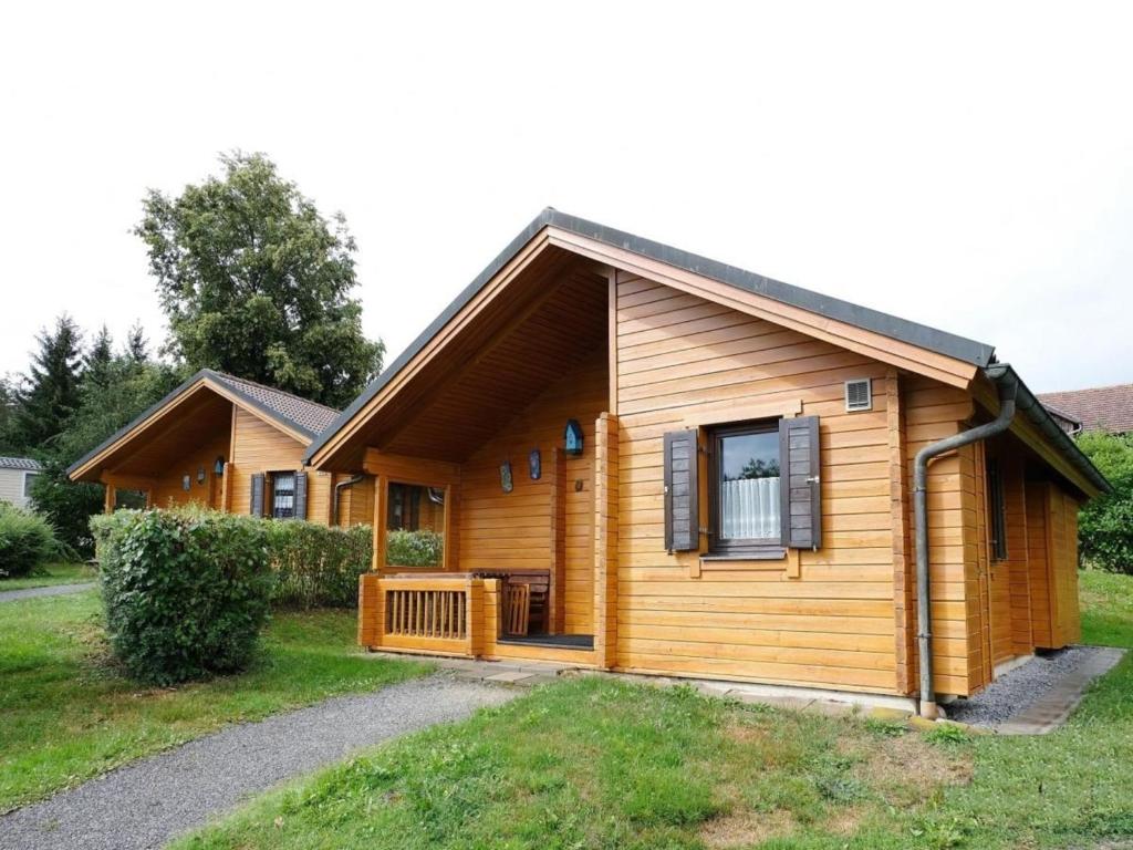 Cabaña de madera con porche y ventana en Ferienhaus Nr 20, Typ B, Feriendorf Jägerpark, Bayerischer Wald en Viechtach