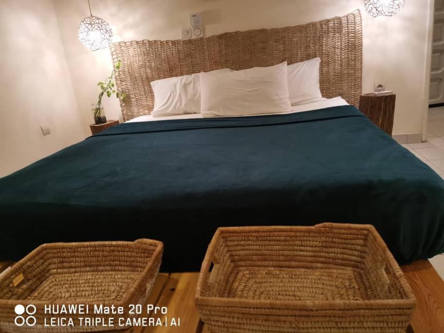 1 dormitorio con 1 cama grande y 2 cestas de mimbre en Délicieux loft en zone marine huppée, en Cotonou