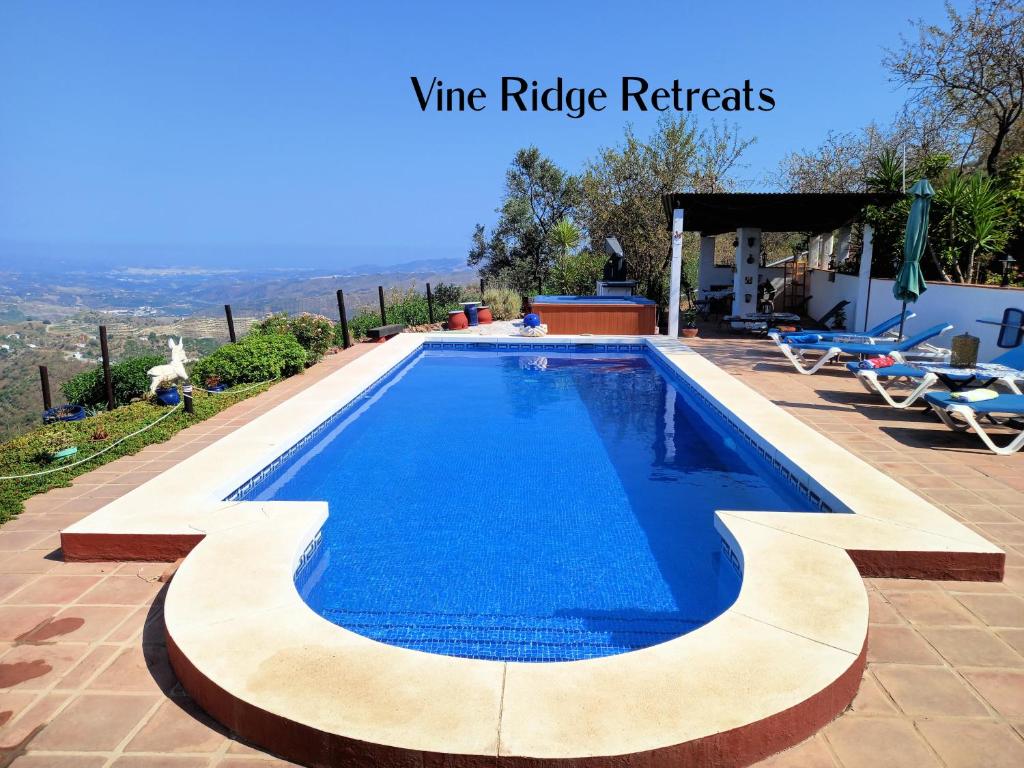 - une piscine dans une villa avec eau bleue dans l'établissement Vine Ridge Studio and Apartment, à Comares