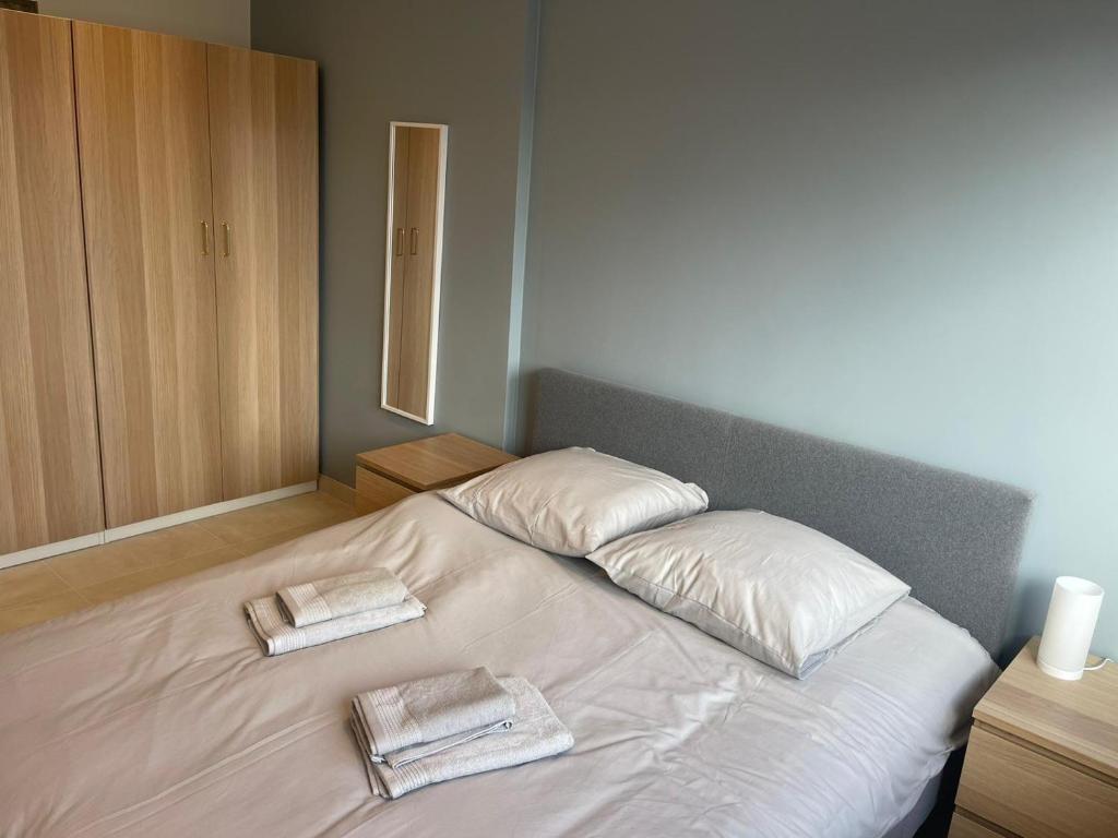 a white bed with two towels on top of it at Le Brasilia - Appartement neuf pour 4 personnes avec terrasse in Strasbourg