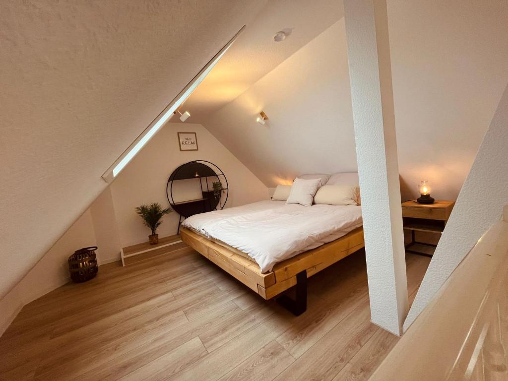 a attic bedroom with a bed and a staircase at Villanelle - Spa & Meer in Büsum