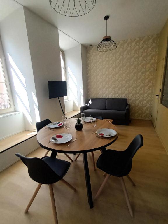 sala de estar con mesa de madera y sillas en Chez David - T2 neuf dans centre historique en Brioude