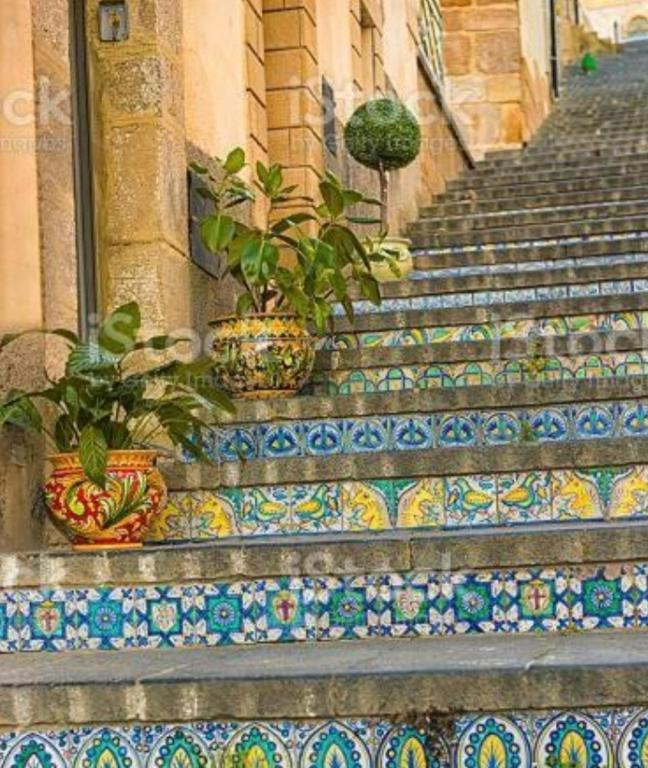 a set of stairs with potted plants on them at Basilicò in Caltagirone