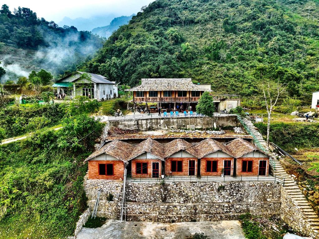 Du Gia Cozy Homestay & Tours في Làng Cac: مبنى على قمة تل مع جبل