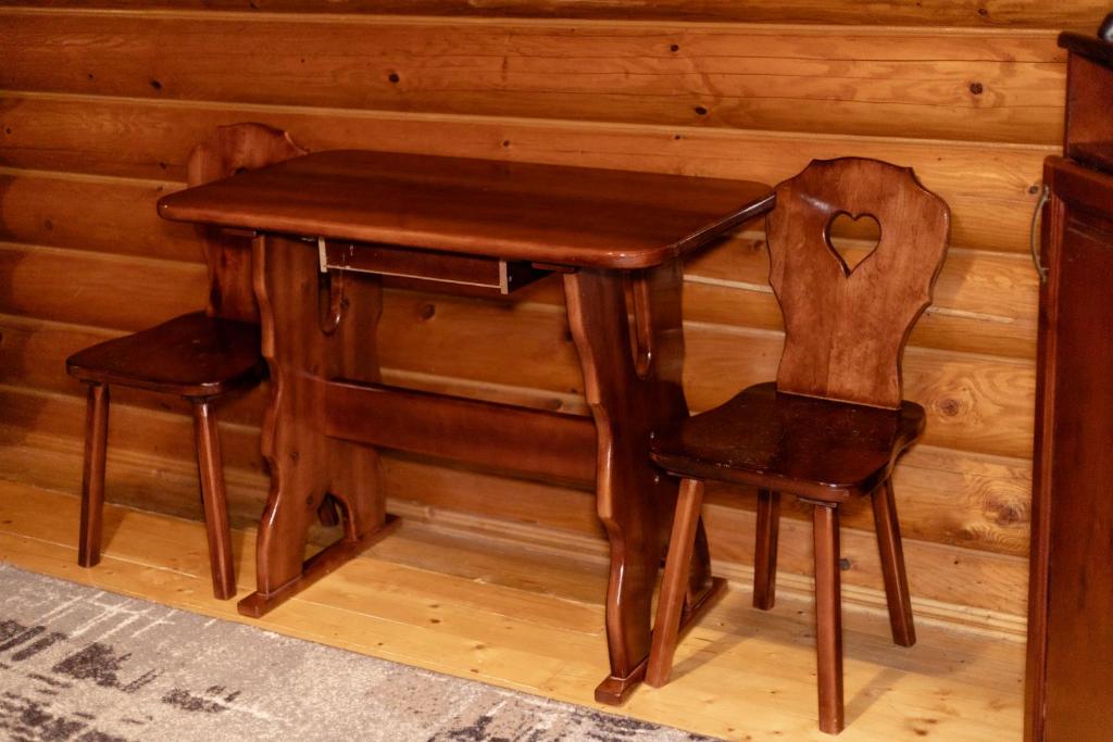 a wooden table and two chairs sitting at a desk at Pysana hata in Volosyanka