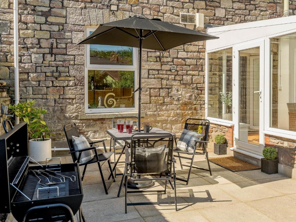 een tafel en stoelen met een parasol op een patio bij 2 bed in Tintern 89323 in Tintern