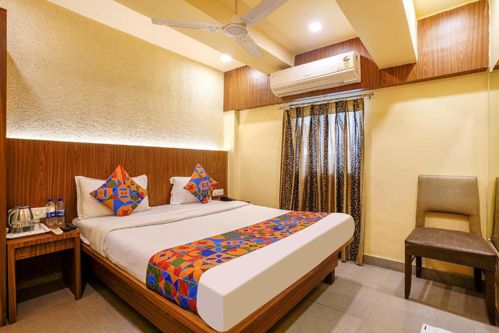 een slaapkamer met een bed, een bureau en een stoel bij FabExpress Swagatham Residency in Mumbai