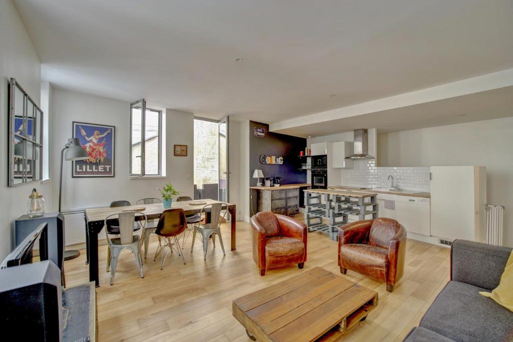 a living room and kitchen with a table and chairs at Le Faubourg - Charmant duplex pour 4 avec parking in Bordeaux