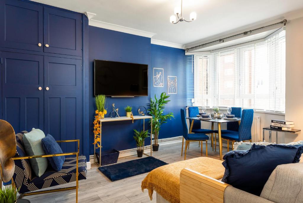un salon aux murs bleus et une salle à manger dans l'établissement West Kensington balcony flat beside Queens club, à Londres