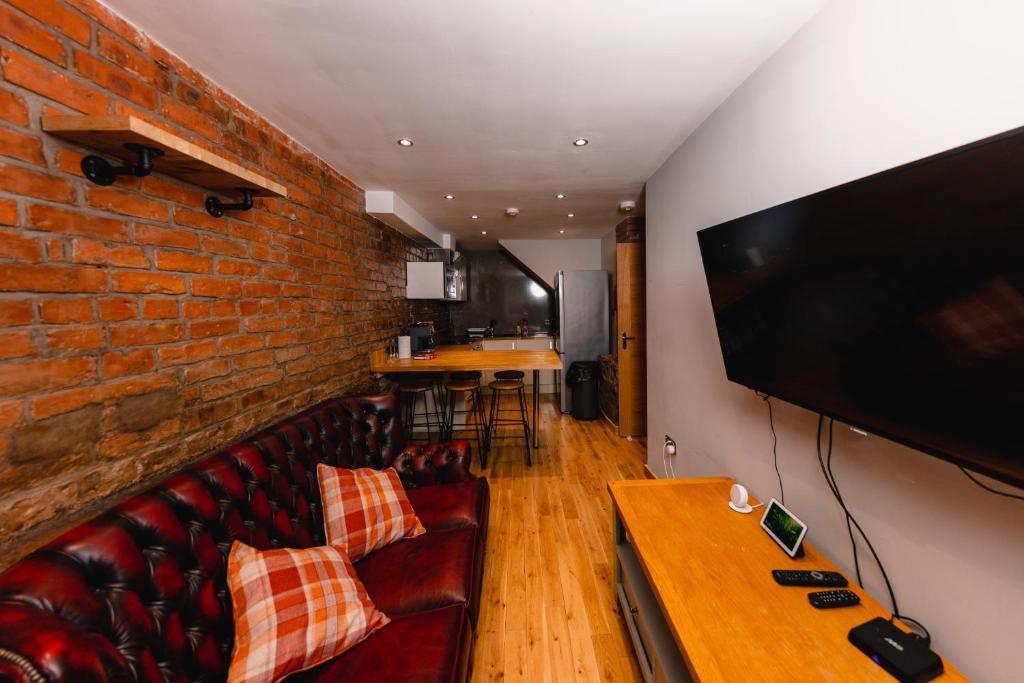 ein Wohnzimmer mit einem Sofa und einem großen Flachbild-TV in der Unterkunft Superb Luxury Quality Central Apartment on Canal in Edinburgh