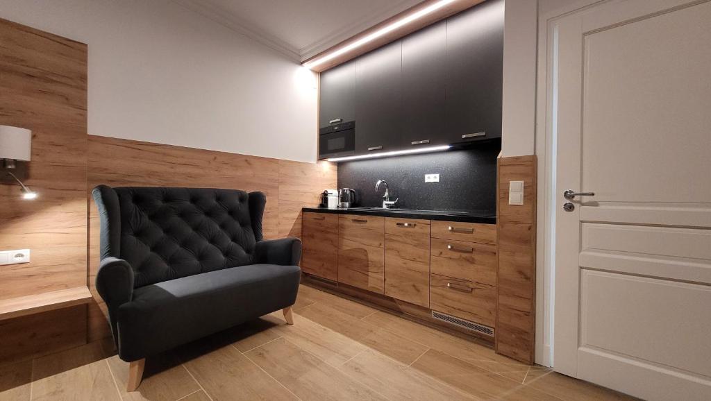 een zwarte stoel in een kamer met een grote televisie bij VIENNA Premium Apartments in Wenen