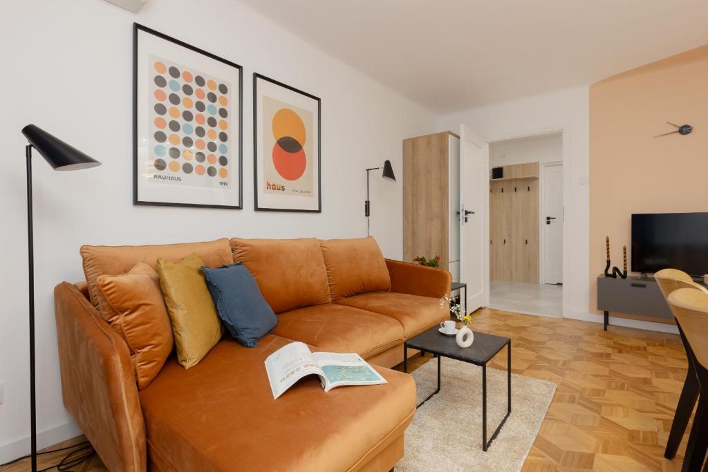 a living room with a brown couch and a tv at Family Apartment with Two Bedrooms and Balcony in Warsaw by Renters in Warsaw
