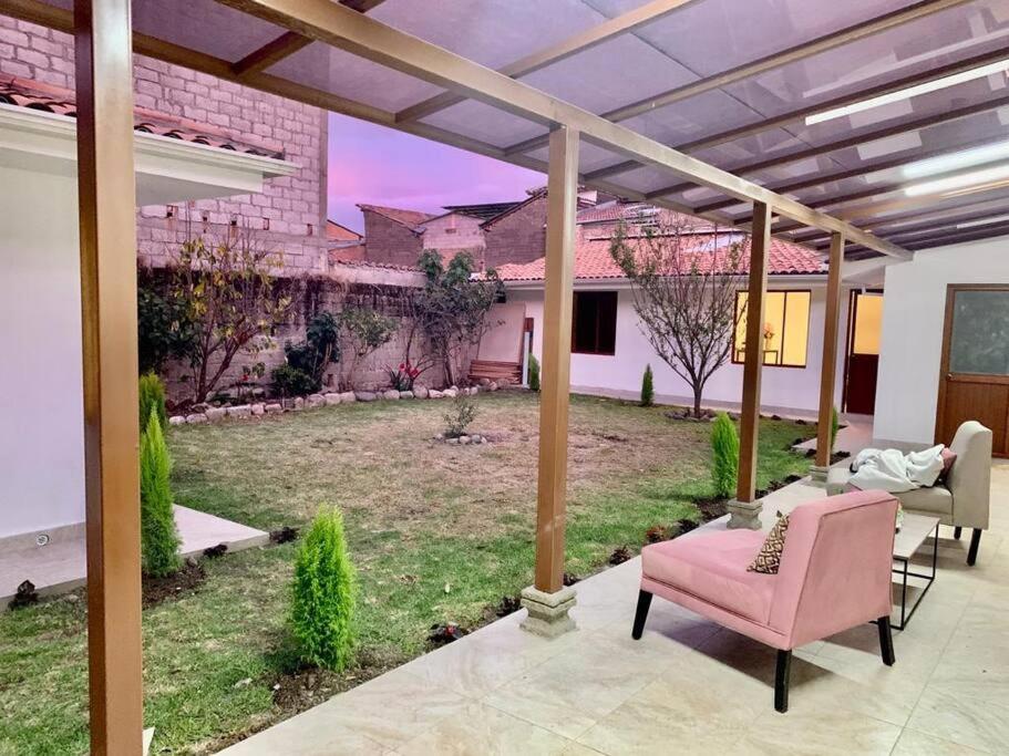 a patio with a pink chair and a yard at Suite Eugenia ubicada en el centro de Estreno in Cuenca