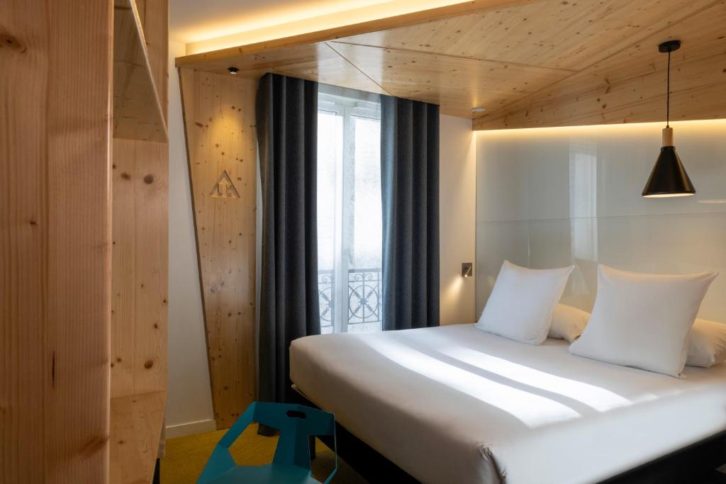 a bedroom with a large bed with a window at Urban Bivouac Hotel in Paris