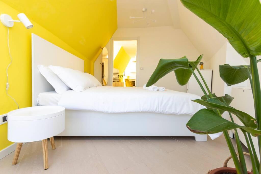 una camera con un letto bianco e una pianta di Kill Bill's Retreat - 10 minuti dal Duomo a Milano