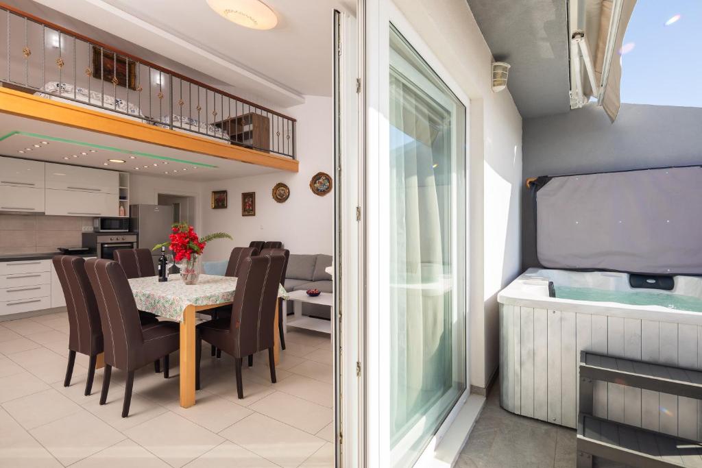 a dining room and kitchen with a table and chairs at Prestige Apartments in Jesenice