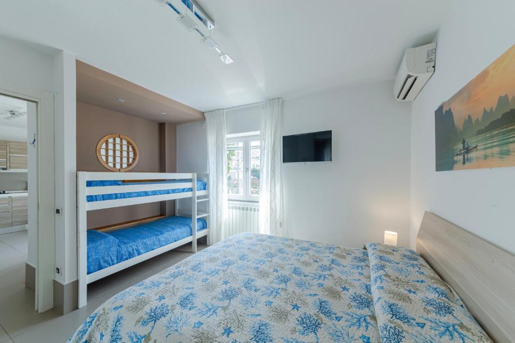 a white bedroom with a blue bed and a window at Casa Mare & Relax in Pozzuoli