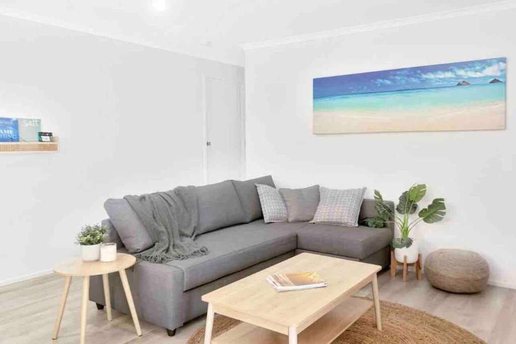 uma sala de estar com um sofá cinzento e uma mesa em Island Villas - Lady Musgrave - Unit 1 em Bundaberg