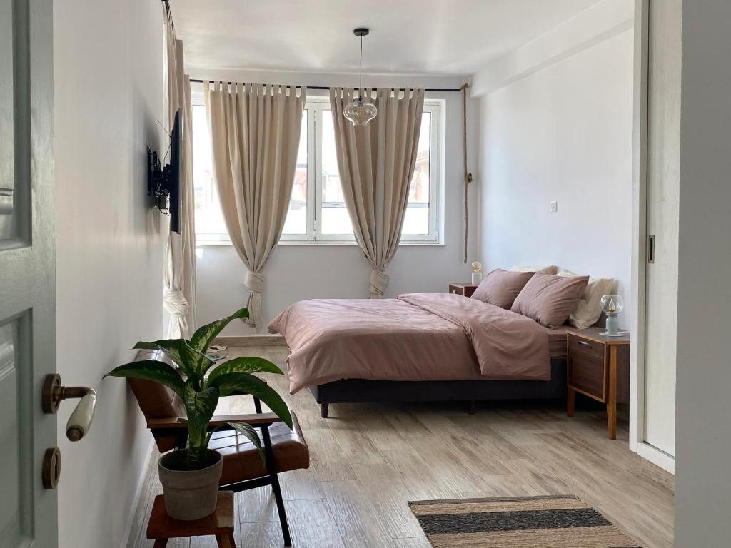 a bedroom with a bed and a potted plant at Loft with a cosy terasse in Limassol