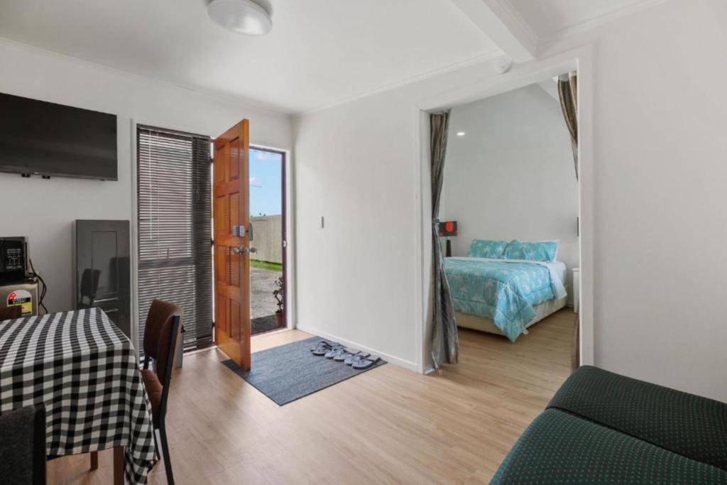 une pièce avec une chambre avec un lit et un miroir dans l'établissement Terracotta Cottage, à Te Awamutu