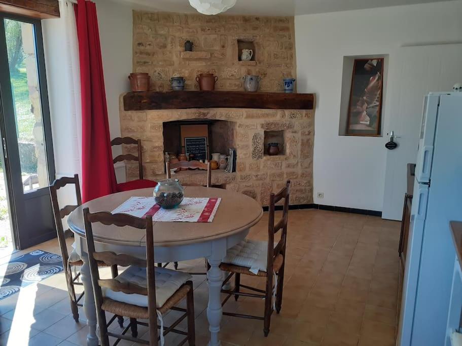 comedor con mesa y chimenea en Gîte du Petit Bois 2/5 pers, en Le Buisson de Cadouin