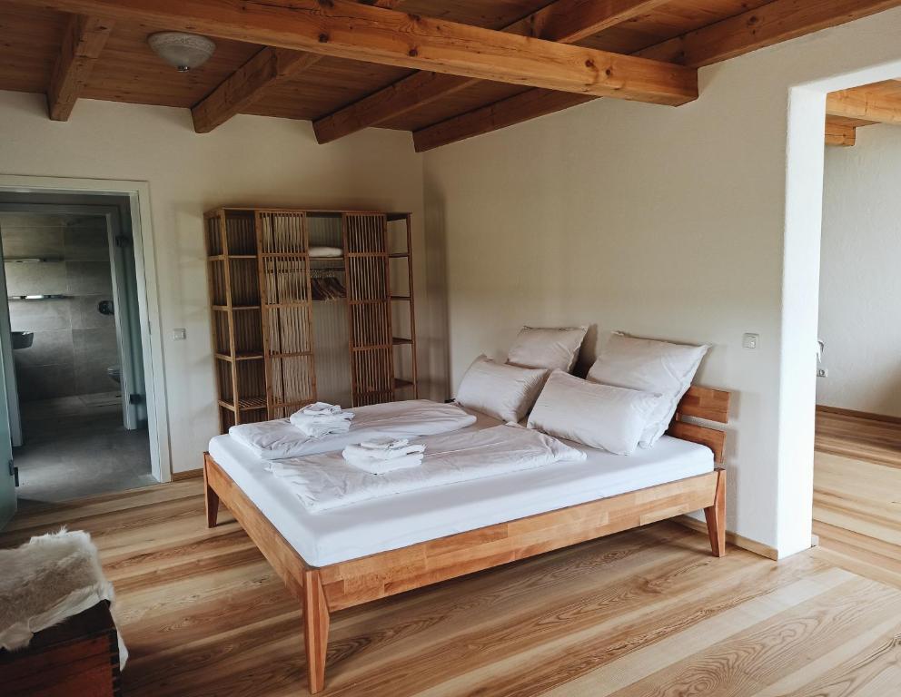 un letto con lenzuola e cuscini bianchi in una stanza di Ferienwohnung Polsing 19 a Palling