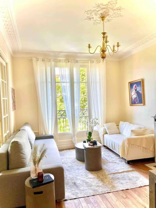 un salon avec un canapé et une fenêtre dans l'établissement 2-Bed Room Cosy Apartment - Central Location, à Paris