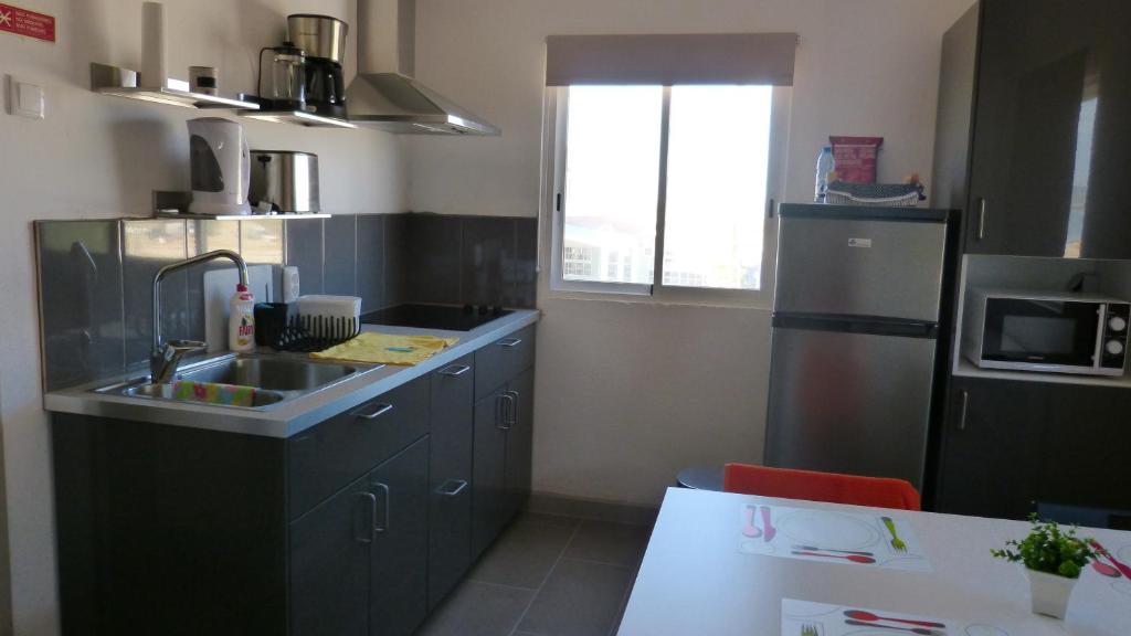 a small kitchen with a sink and a refrigerator at Fragateira in Aldeia de Brescos