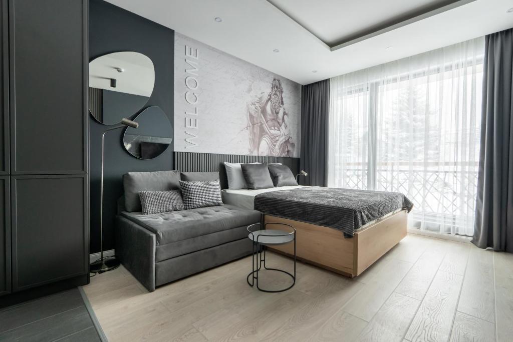 1 dormitorio con 1 cama y 1 sofá en Marrilux apartments Residence Hill en Kopaonik