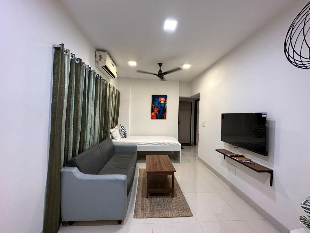 a living room with a couch and a tv at 1bed room Mumbai theme Lower Parel in Mumbai