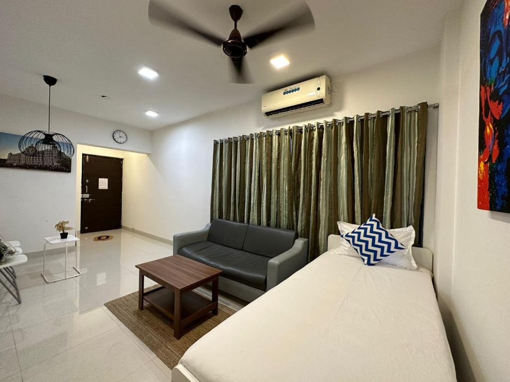a bedroom with a bed and a couch and a chair at 1bed room Mumbai theme Lower Parel in Mumbai