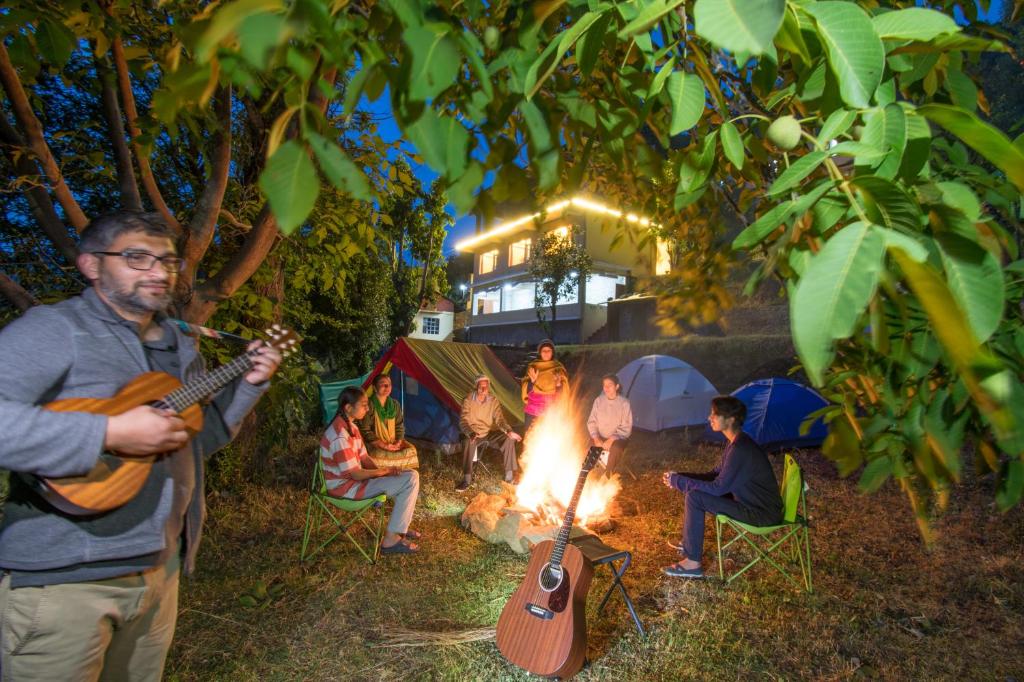 Summer Breeze في Shogi: مجموعة من الناس يجلسون حول النار مع الغيتار