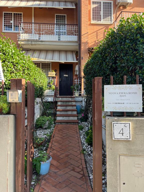 a brick walkway leading to a building with a balcony at Nuova Fiera Apart. in Ponte Galeria