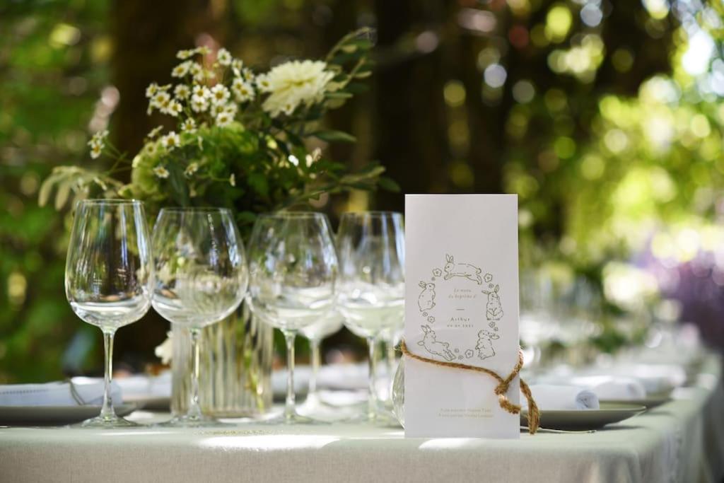 - une table avec des verres à vin et une cheminée avec une pièce centrale dans l'établissement Clos Saint-Priscus - Gîte de Charme - Les Bastides d'Edouard en Bourgogne, à Saint-Bris-le-Vineux