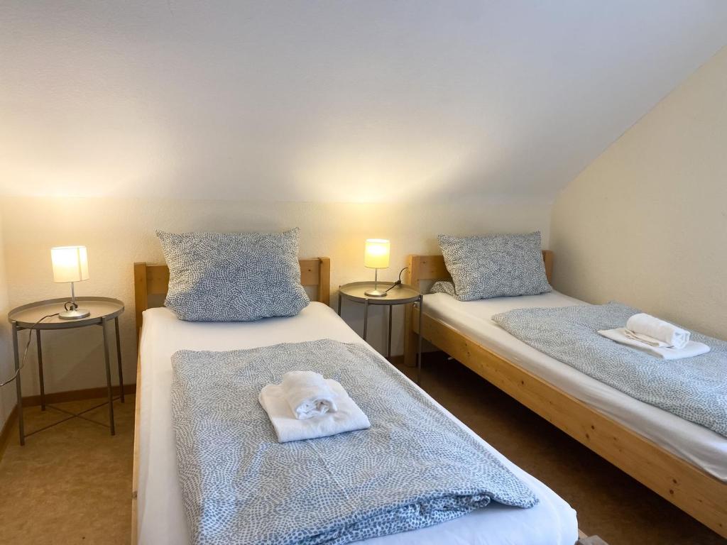 2 Einzelbetten in einem Zimmer mit 2 Lampen in der Unterkunft Monteurpension Monika in Marktheidenfeld
