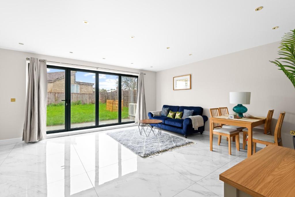 a living room with a blue couch and a table at Stylish Sparkling Brand New 3 bed house in Heston