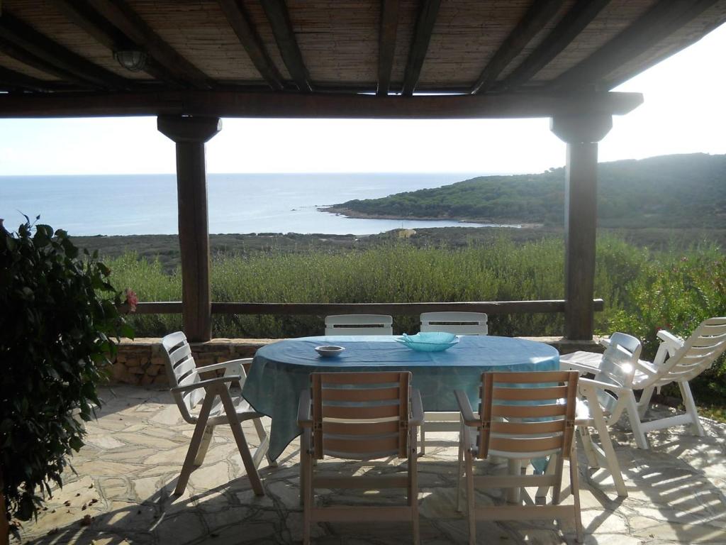 een tafel en stoelen op een patio met uitzicht op de oceaan bij Villetta Bouganville vista mare in Porto Ottiolu
