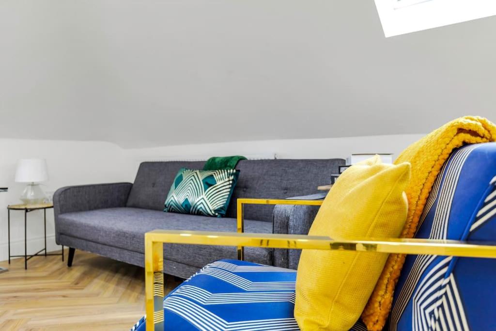 a living room with a couch and a yellow chair at Chic 4 person penthouse & views West London W7 Modern free parking (4 occupancy) in London