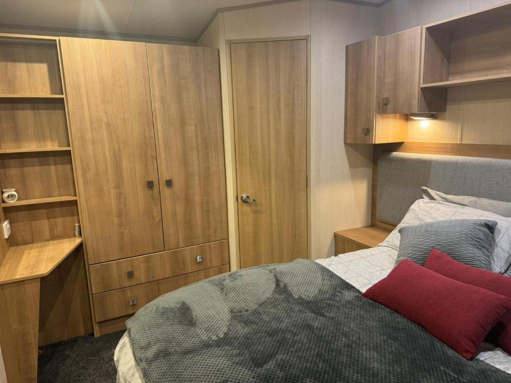 a bedroom with a bed and wooden cabinets at Nick's Retreat in Clitheroe