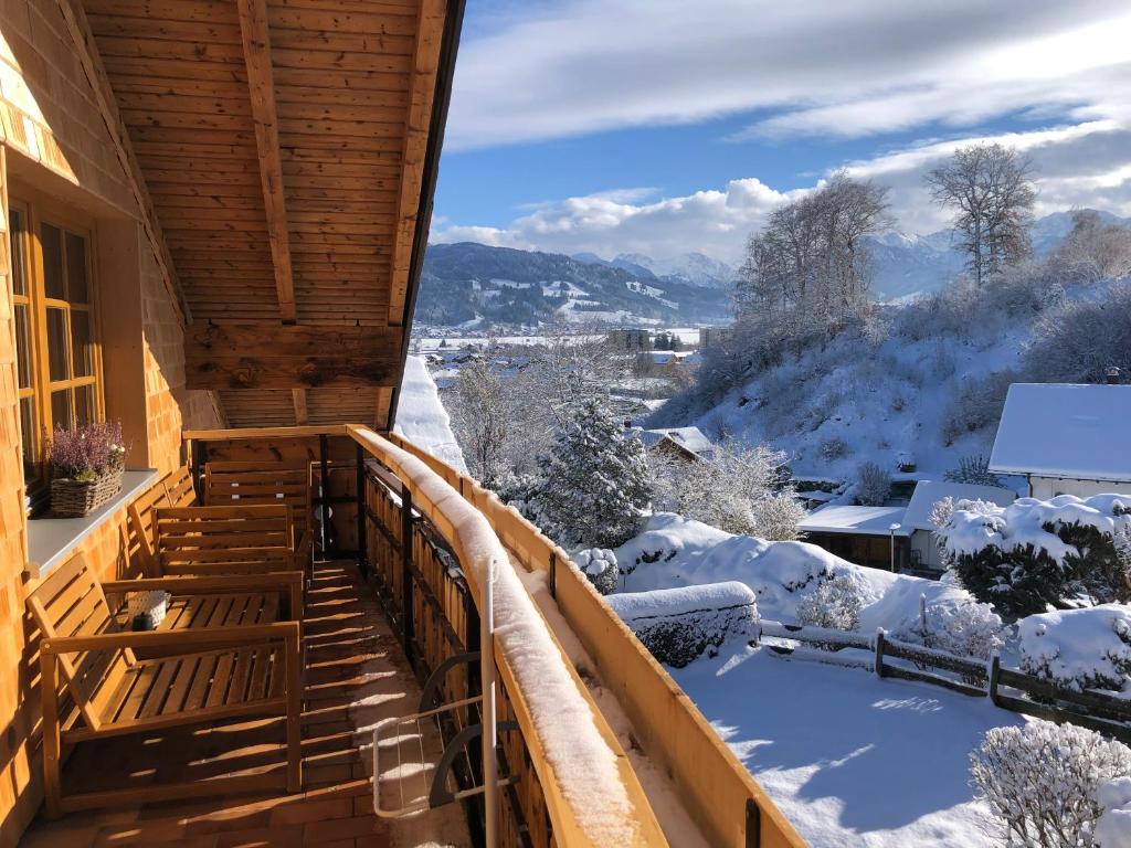 un balcone di una casa con neve per terra di Nagelfluh Hüs a Blaichach